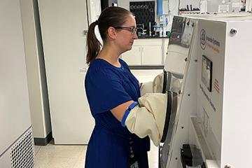 ARS molecular biologist Karley Mahalak in front of an anaerobic chamber