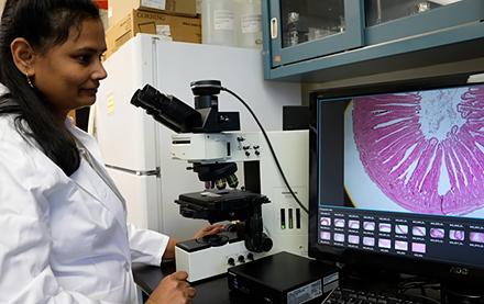 ARS research biologist Revathi Shanmugasundaram in front of a screen