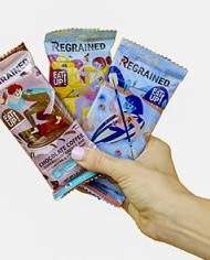 A hand holding three packaged ReGrained bars.