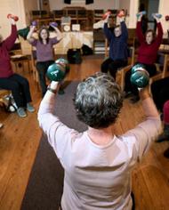 Older adults exercising with hand weights. 
